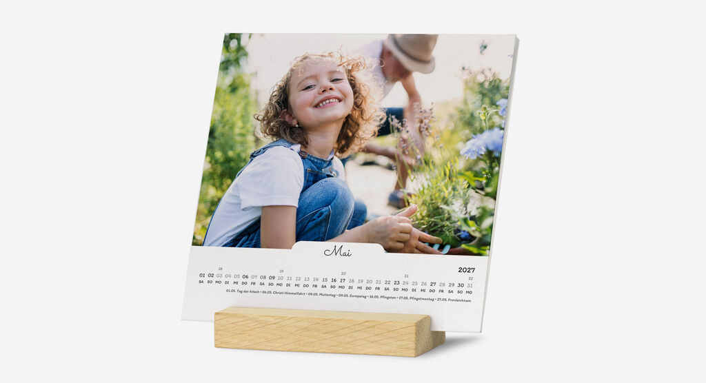 Ein fröhliches Kind betrachtet Blumen in einem Kalender.