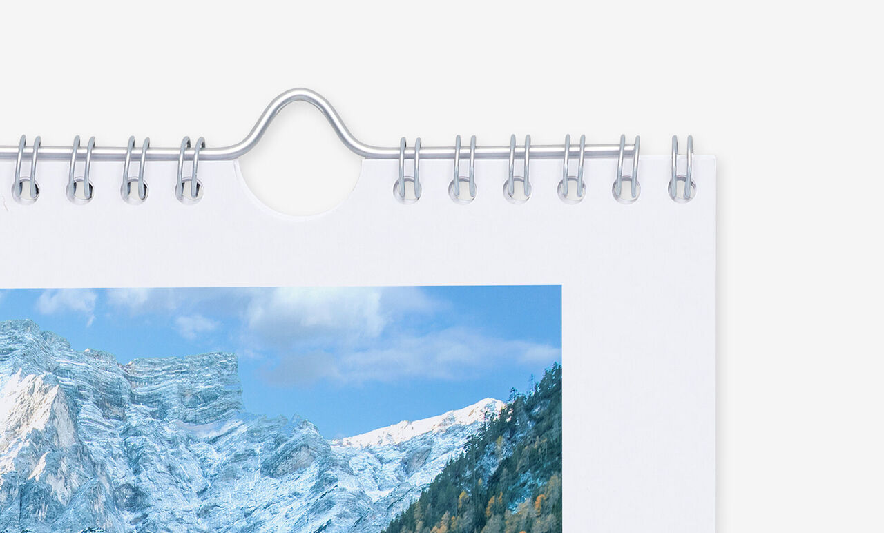 Detailansicht der silber-metallisch glänzenden Spiralbindung mit Aufhängevorrichtung.