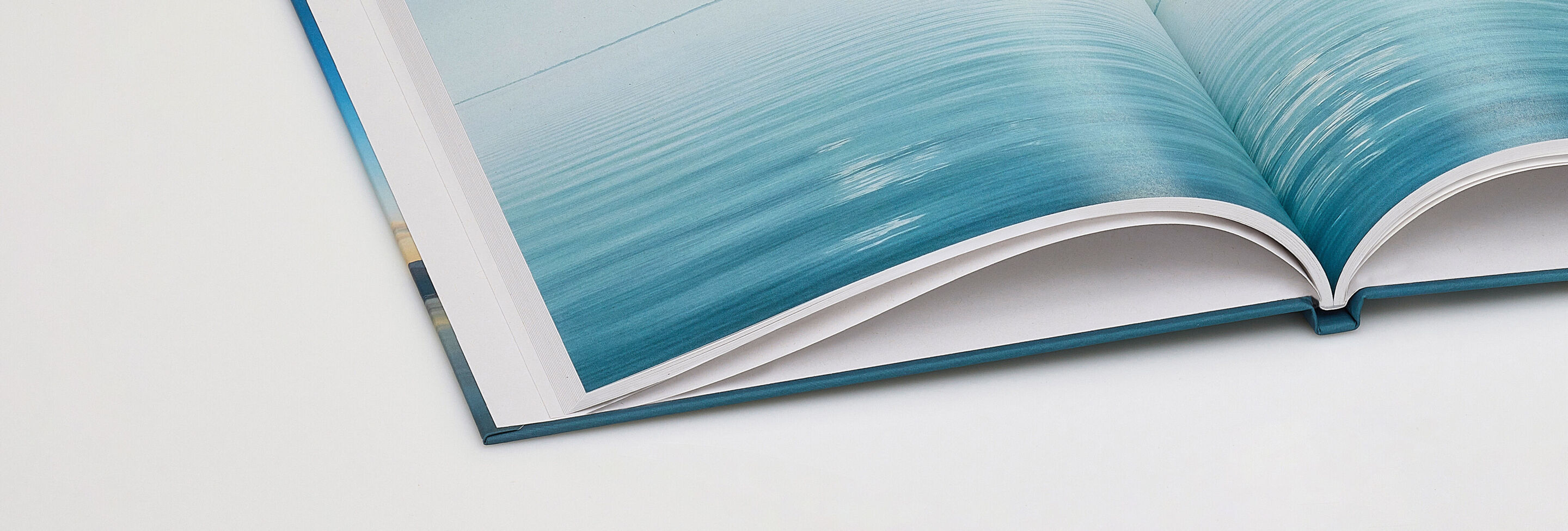 Aufgeschlagenes Fotobuch mit 100% Blauer Engel zertifiziertem Recyclingpapier.