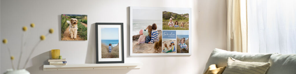Es werden verschiedene Wandbilder wie eine Leinwand und ein gerahmtes Bild mit persönlichen Familien- und Tierfotos an einer Wohnwand gezeig