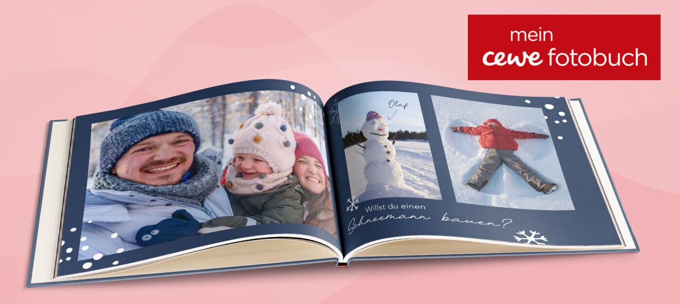 Aufgeschlagene Doppelseite eines CEWE FOTOBUCHs mit Fotos von einer Familie im Schnee und winterlichem Seitendesign