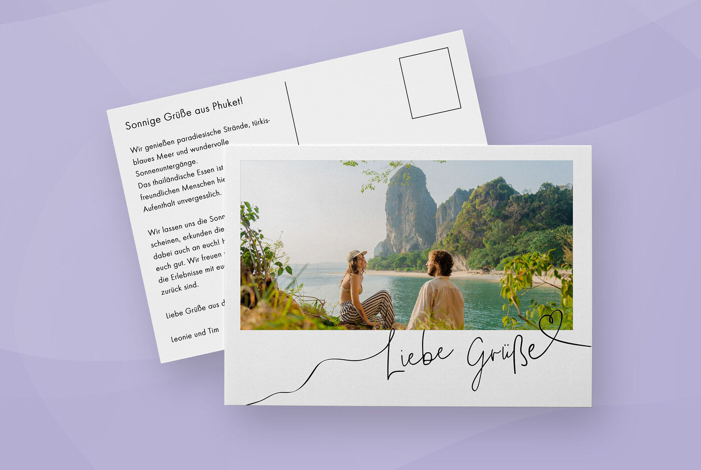 Postkarte mit Aufschrift "Liebe Grüße" und Foto eines Paares, das in einer Bucht sitzt
