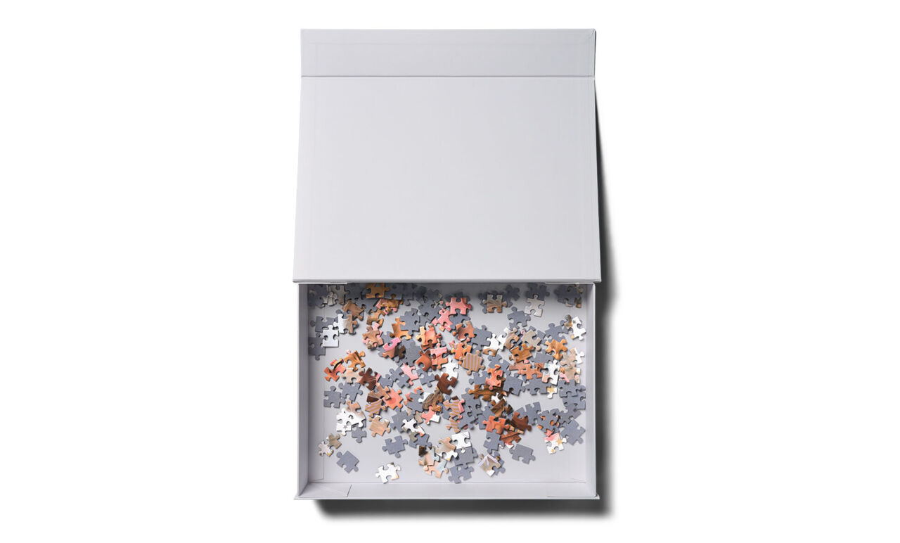 Geöffnete weiße Schachtel mit Puzzleteilen
