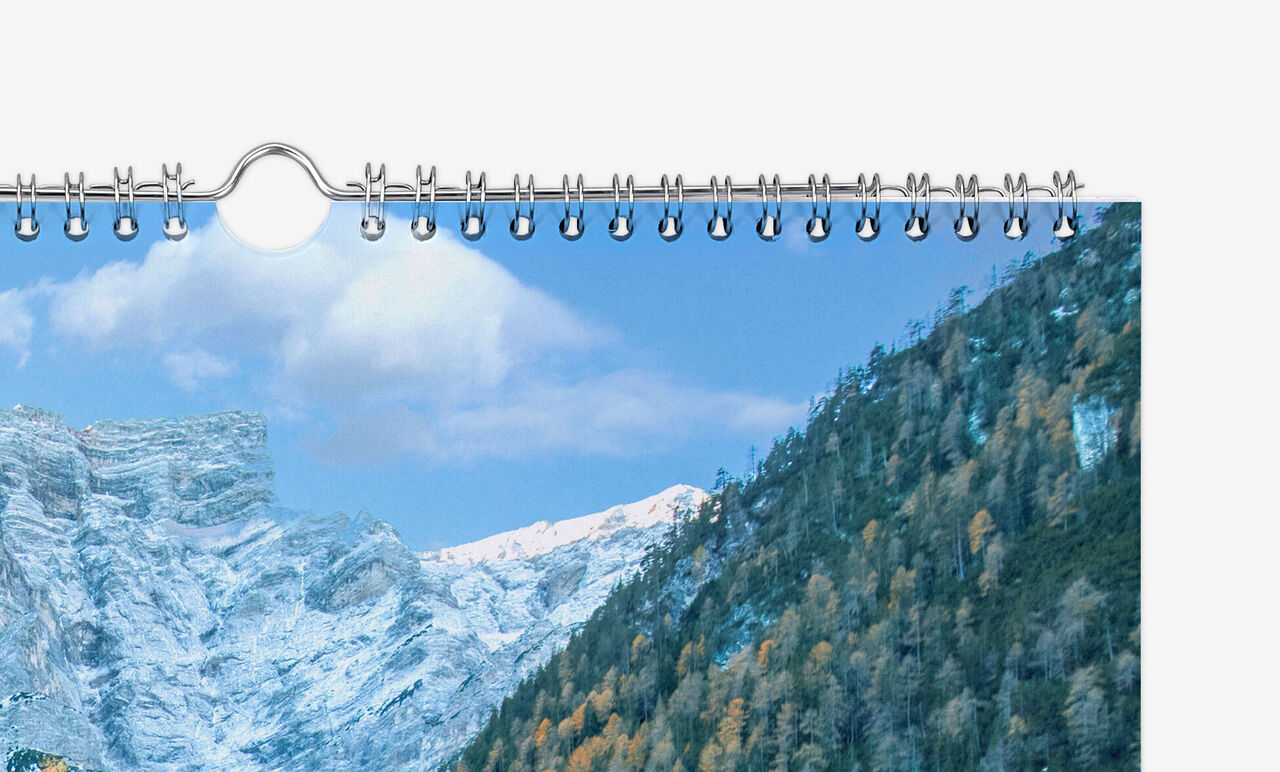 Detailansicht der silber-metallisch glänzenden Spiralbindung mit Aufhängevorrichtung.