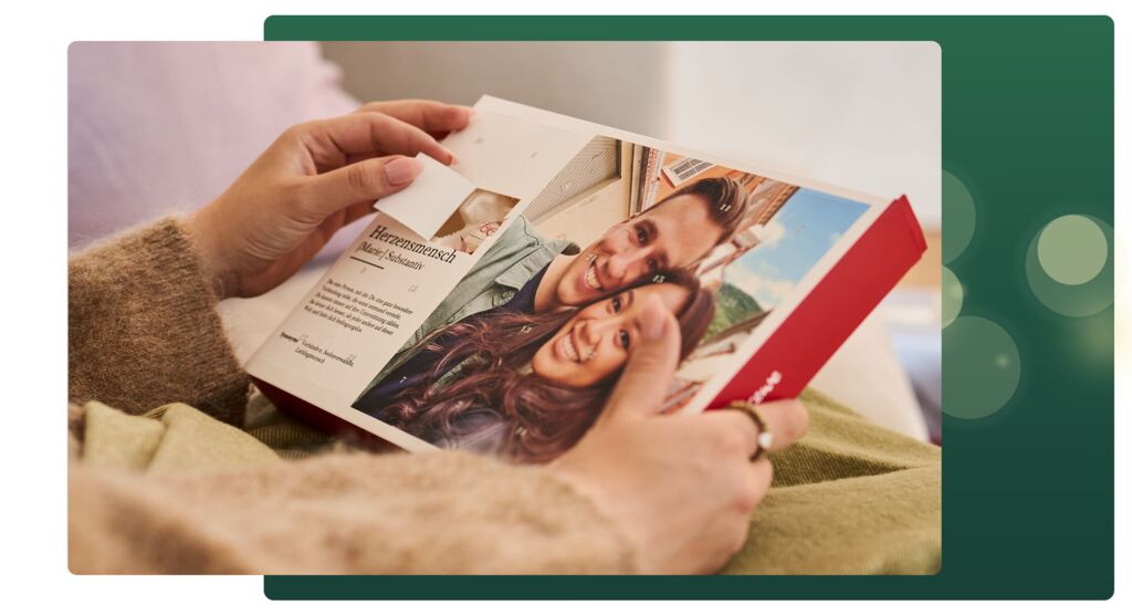 Hand öffnet Adventskalender mit eigenem Foto, aufgedruckt steht Herzensmensch