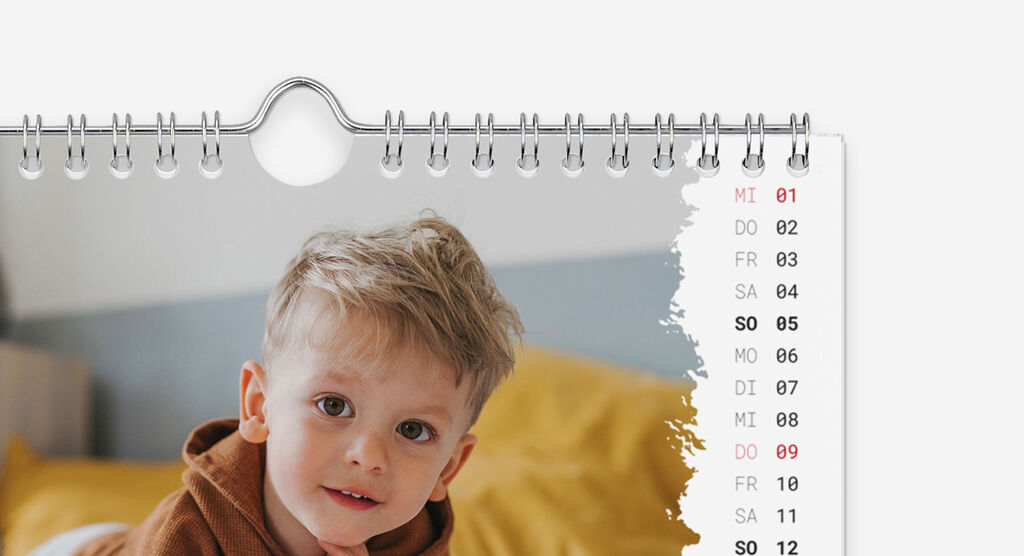 Ein schöner Wandkalender mit einem liebevollen Kalenderblatt und einem Schnappschuss eines lächelnden Kindes.
